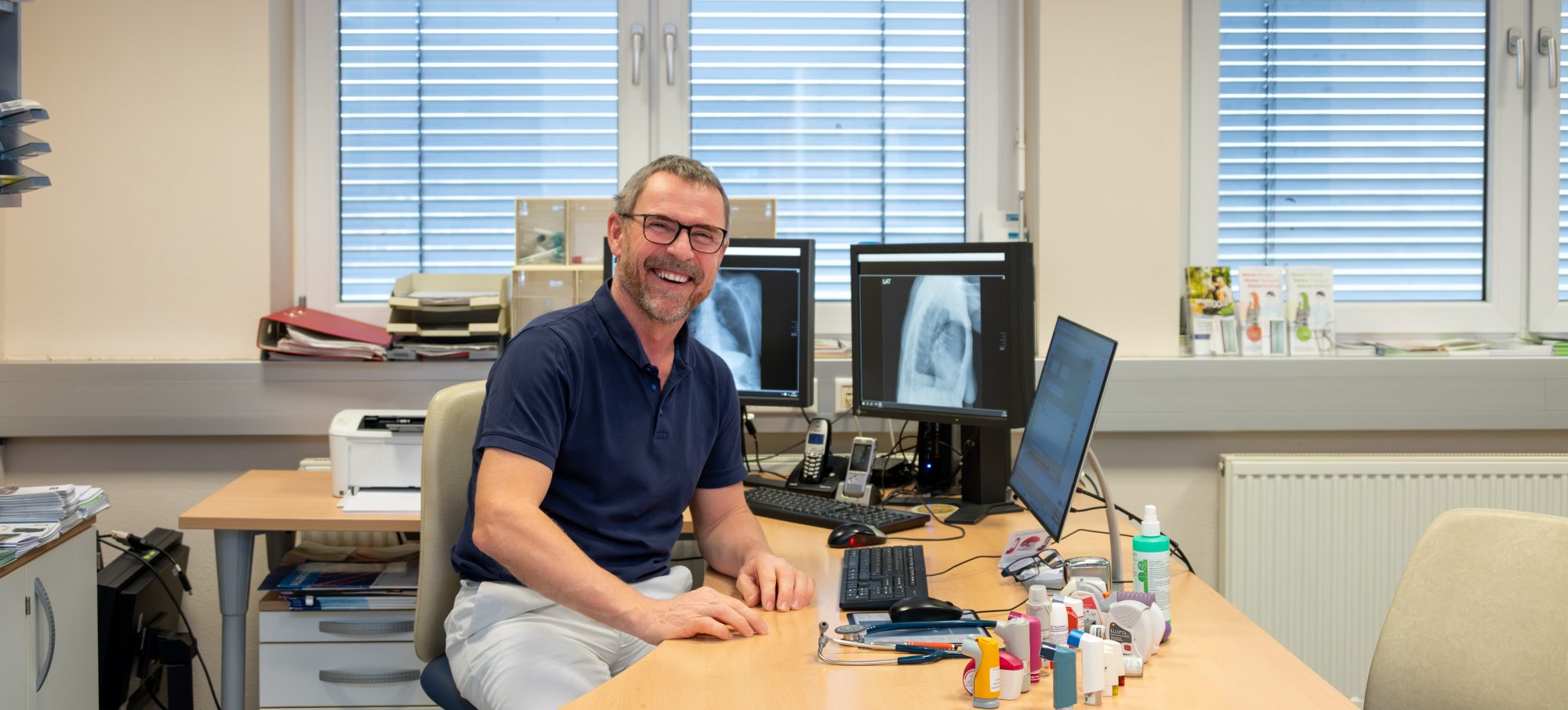 Dr. Flasch in seiner Ordination am Schreibtisch sitzend