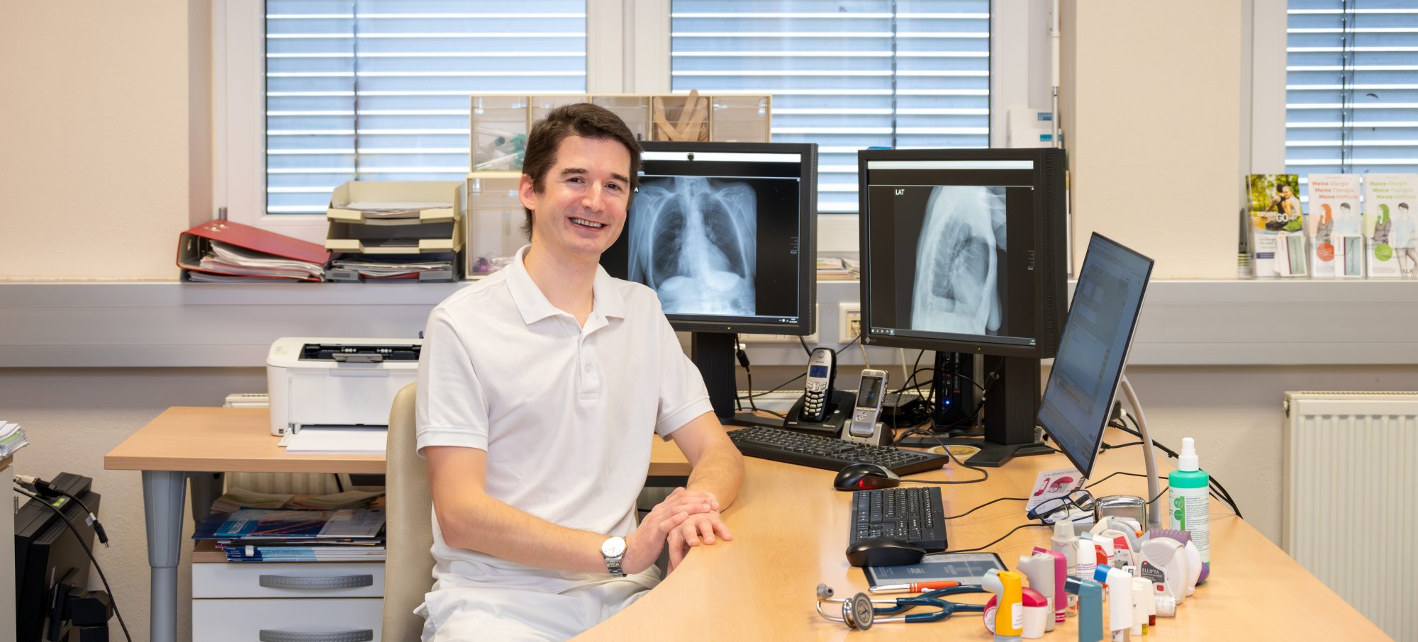 Dr. Tiefenbacher in der Ordination am Schreibtisch sitzend